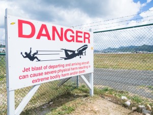A warning to pedestrians and cars on the road that separates the runway and beach on Sint Maarten