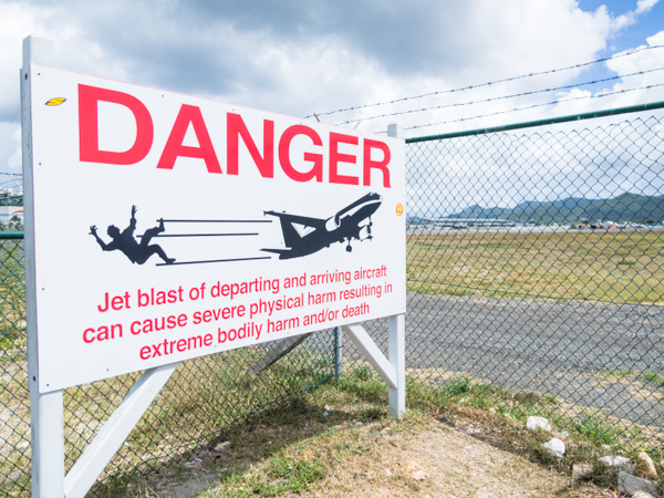 A warning to pedestrians and cars on the road that separates the runway and beach on Sint Maarten