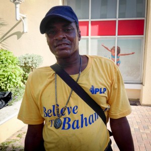 A working man wears a shirt featuring the slogan of the PLP party in the Bahamas