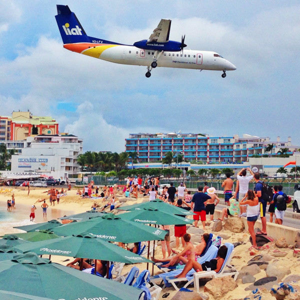 A Liat Air Dash-8 lands over the beach on to Runway 10 at Princess Juliana Airport on Sint Maarten